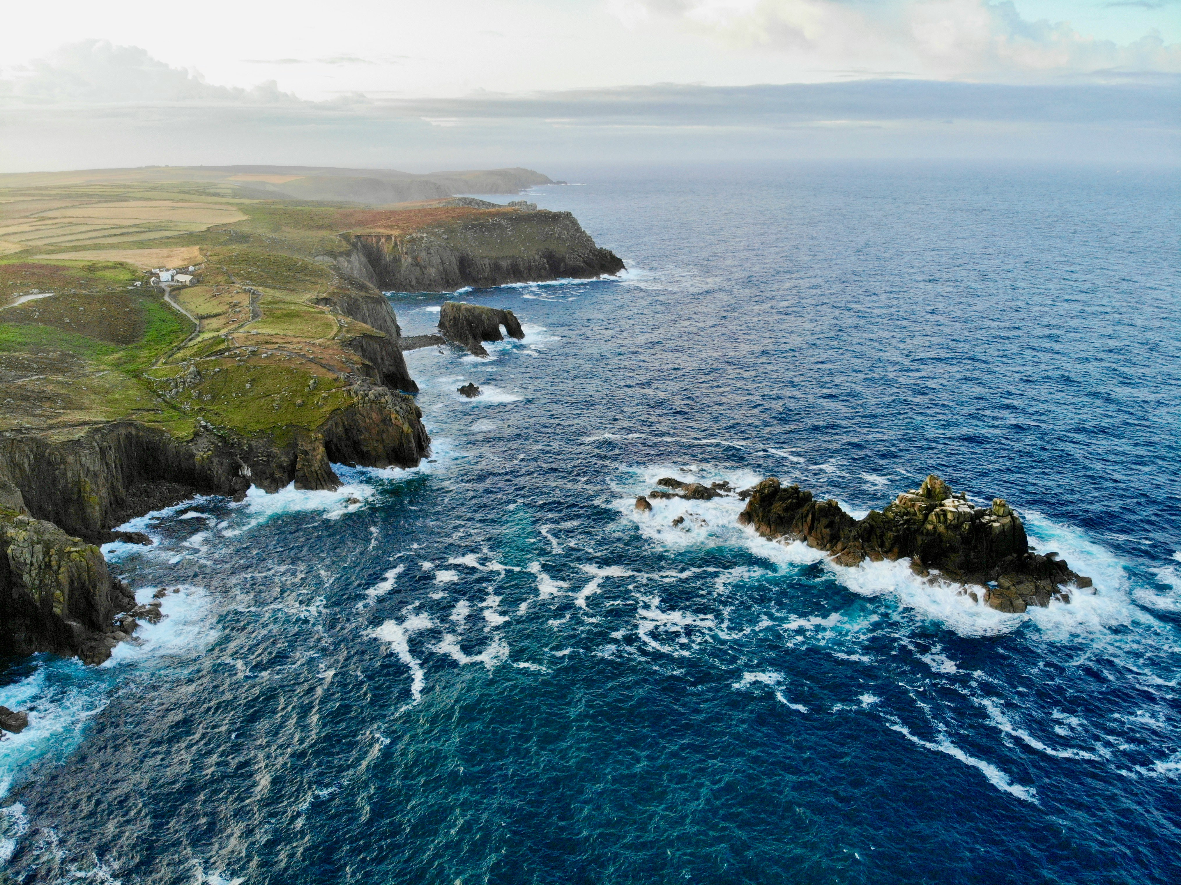 aerial view of green and brown mountain beside sea during daytime